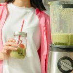 緑のスムージーを持つ女性。夏の腸内環境を整える食生活のイメージ