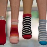 色とりどりの靴下をはいた足が並んでいる様子