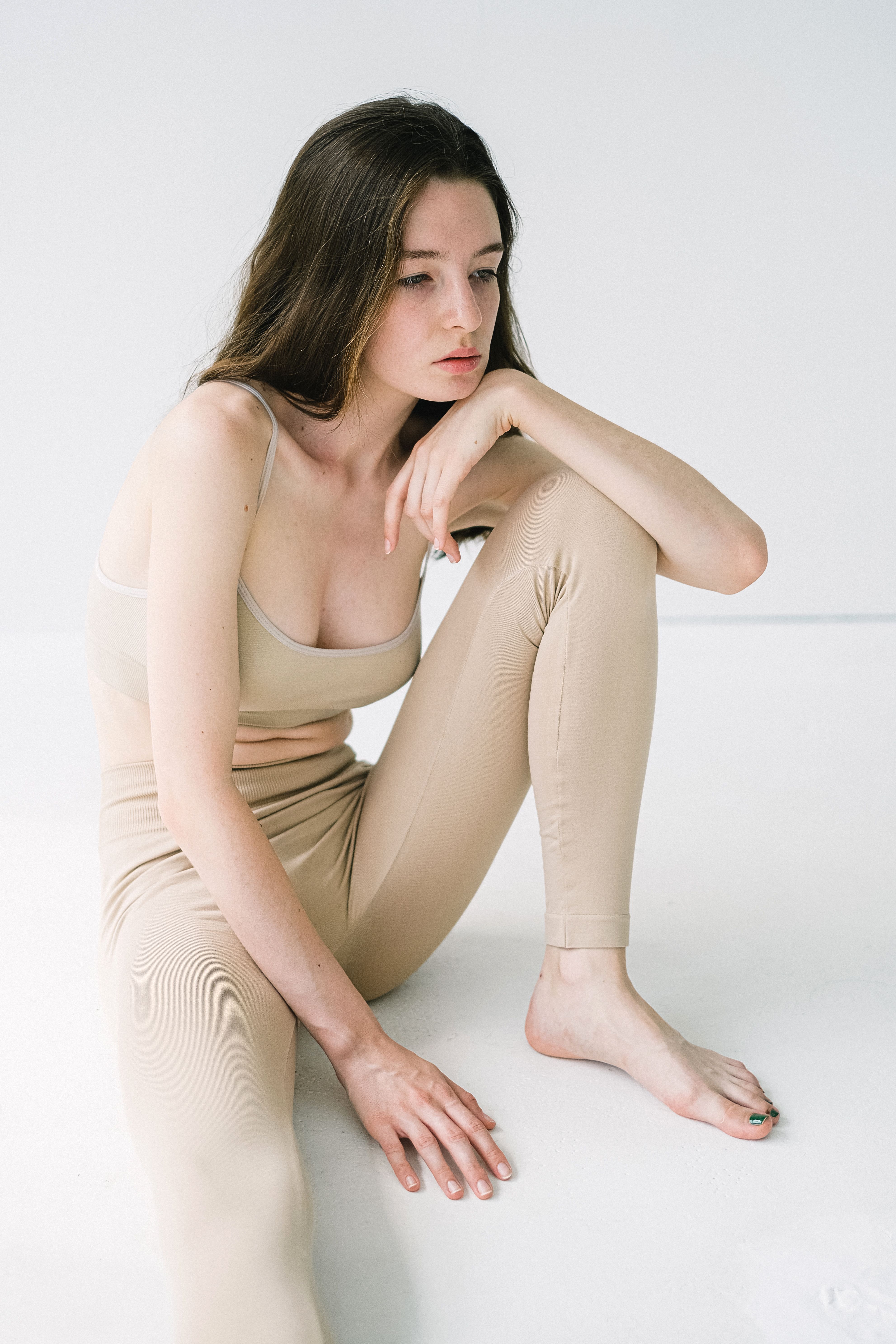 床に座り脚のラインが気になる女性|前もも太りの悩み