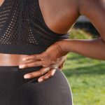 腰に手を当てる女性の後ろ姿