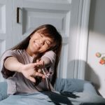 朝ベッドの上で伸びをする女性