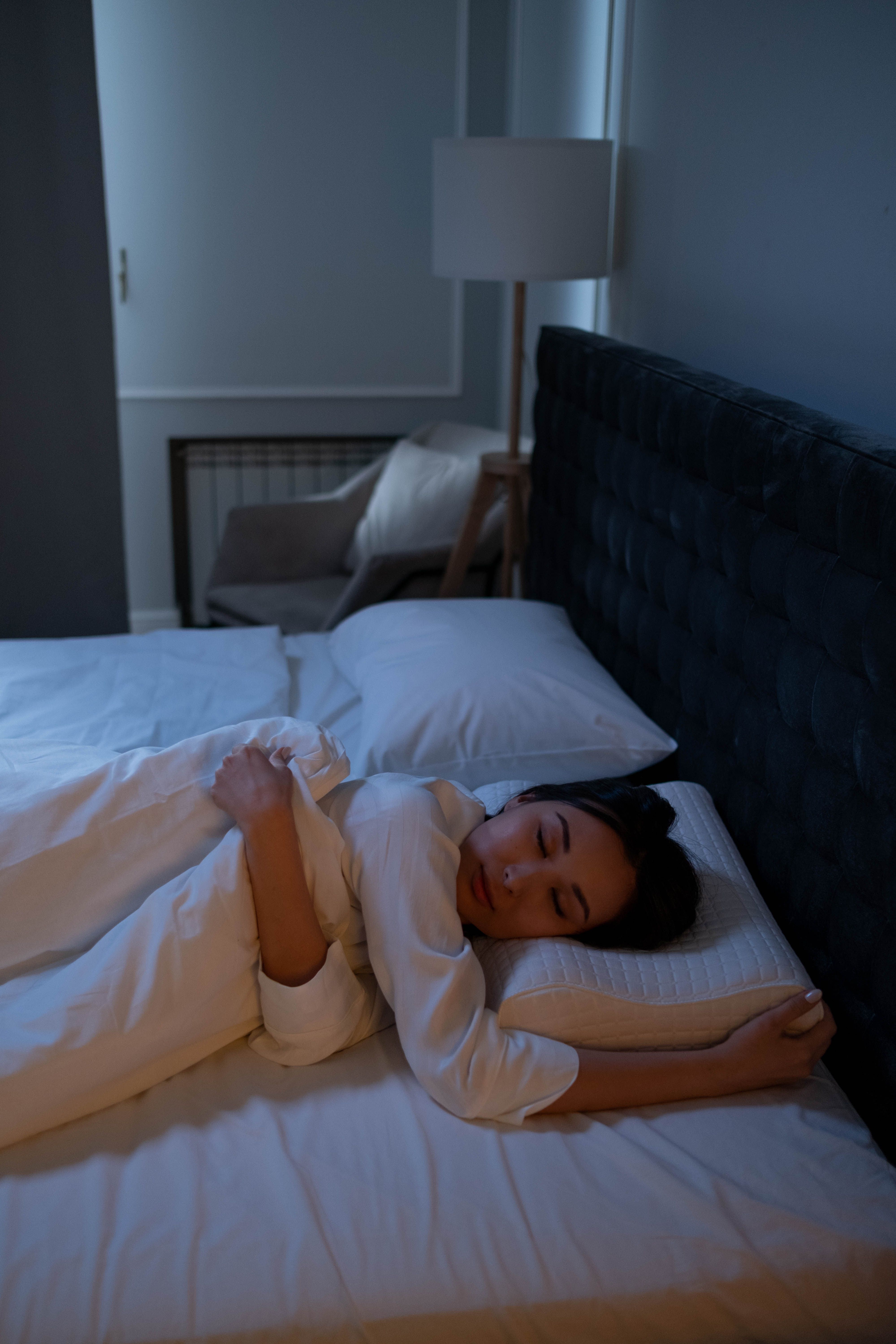 こむら返りが寝てる時に起こる原因|夜のベッドで眠る40代女性