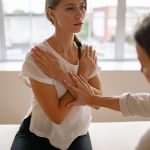 肩まわりのストレッチをサポートされる女性